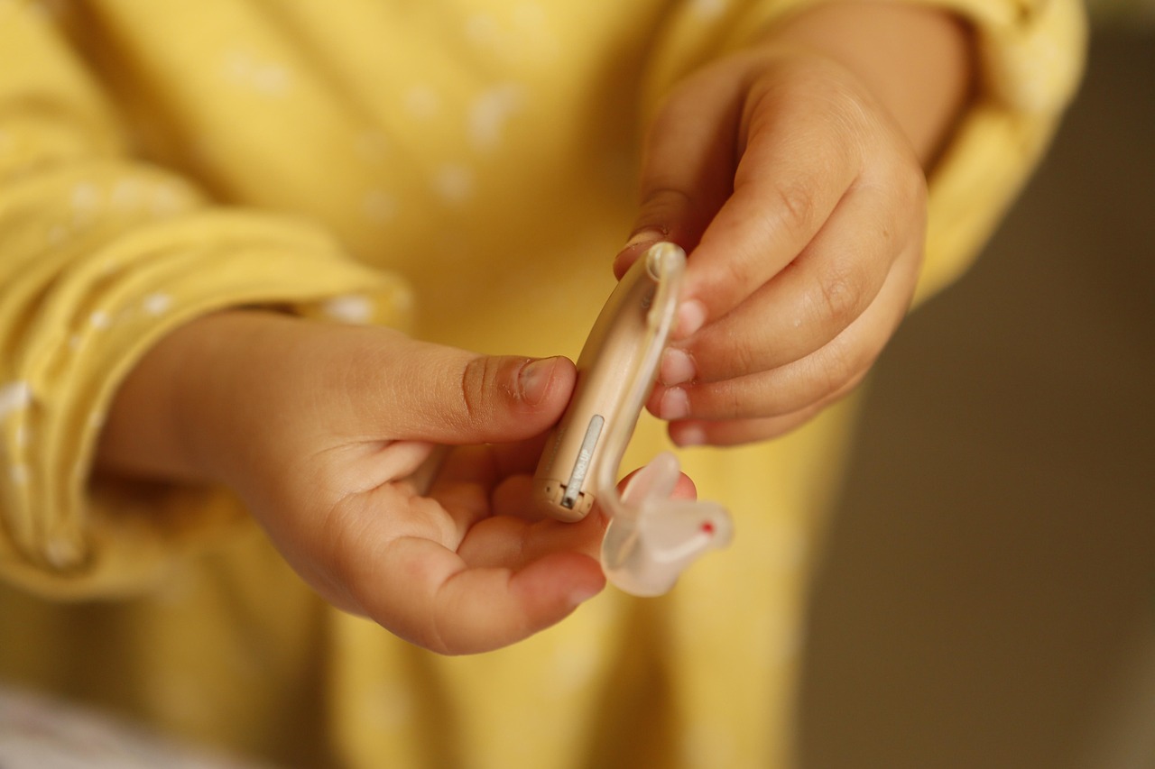 Close-up of a modern behind-the-ear hearing aid with dome, the type of device discussed in speech-in-noise testing